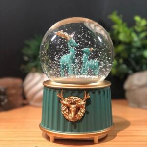Pilli Işıklı Müzikli Kar Küresi–İki Geyikli Yeşil Figürlü Eğlenceli Masaüstü Biblo, LED Aydınlatmalı Dekoratif Hediyelik Kar Küresi (5286)